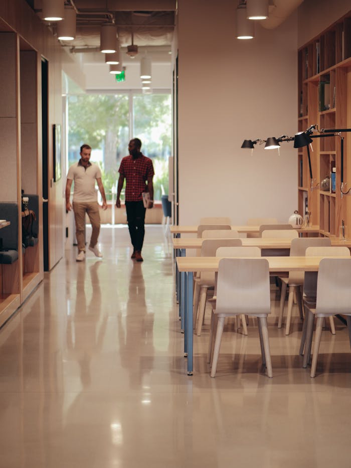 about-img Two colleagues walking through a modern office space, discussing ideas and projects.