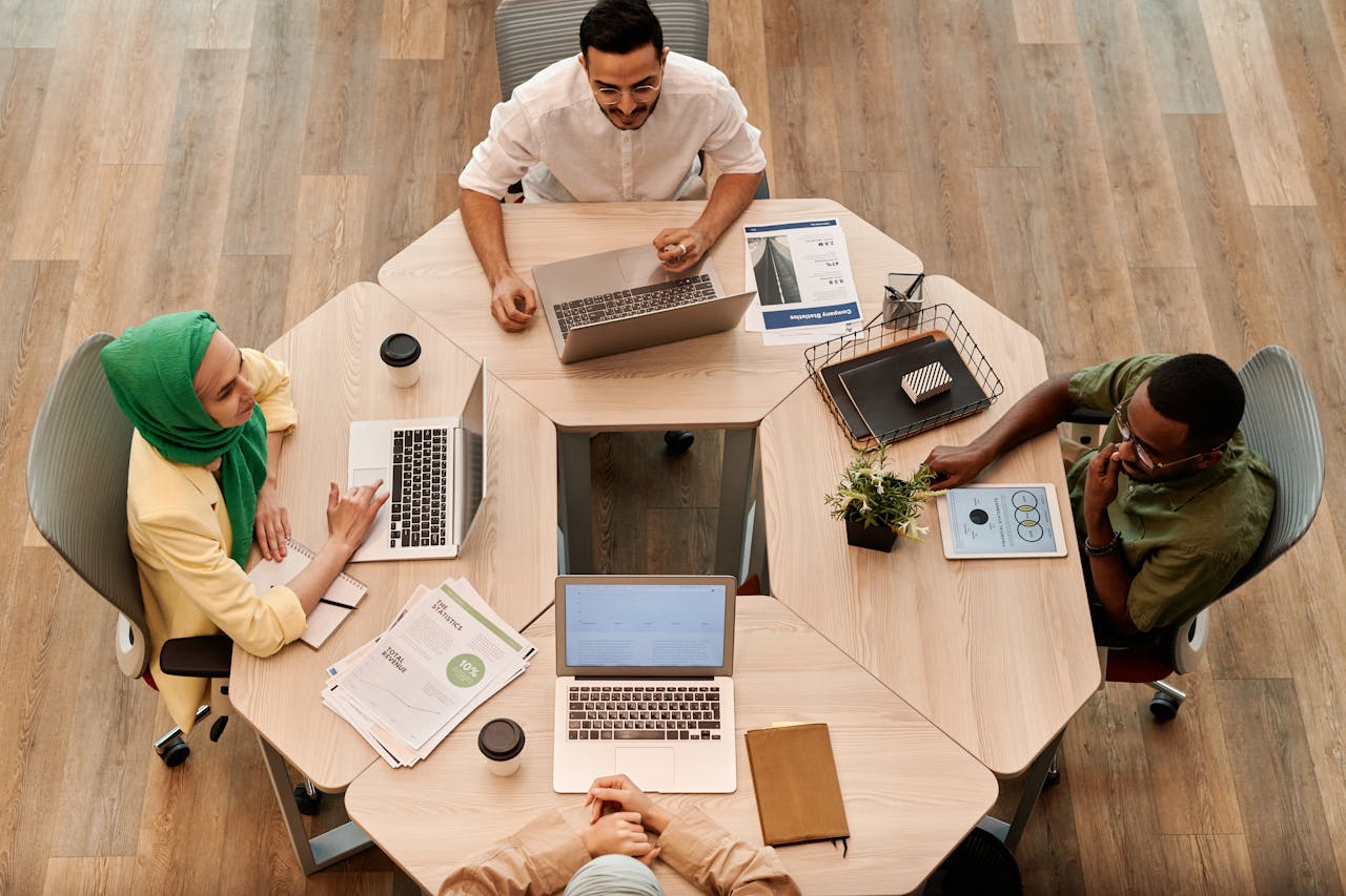 our-experience Top view of diverse coworkers collaborating at a modern office table.